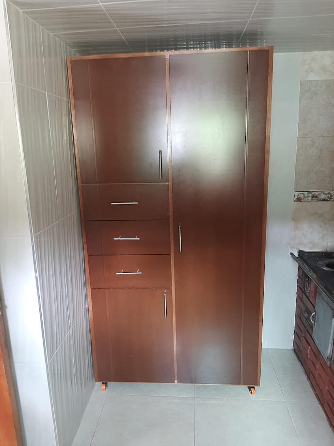 Clóset de madera color caoba con diseño liso y moderno, puertas abatibles, tres cajones verticales y manijas metálicas rectas.